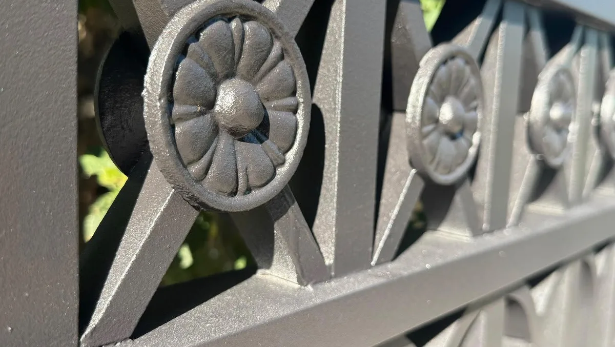 Restored ornamental fence detail with fresh metallic coating